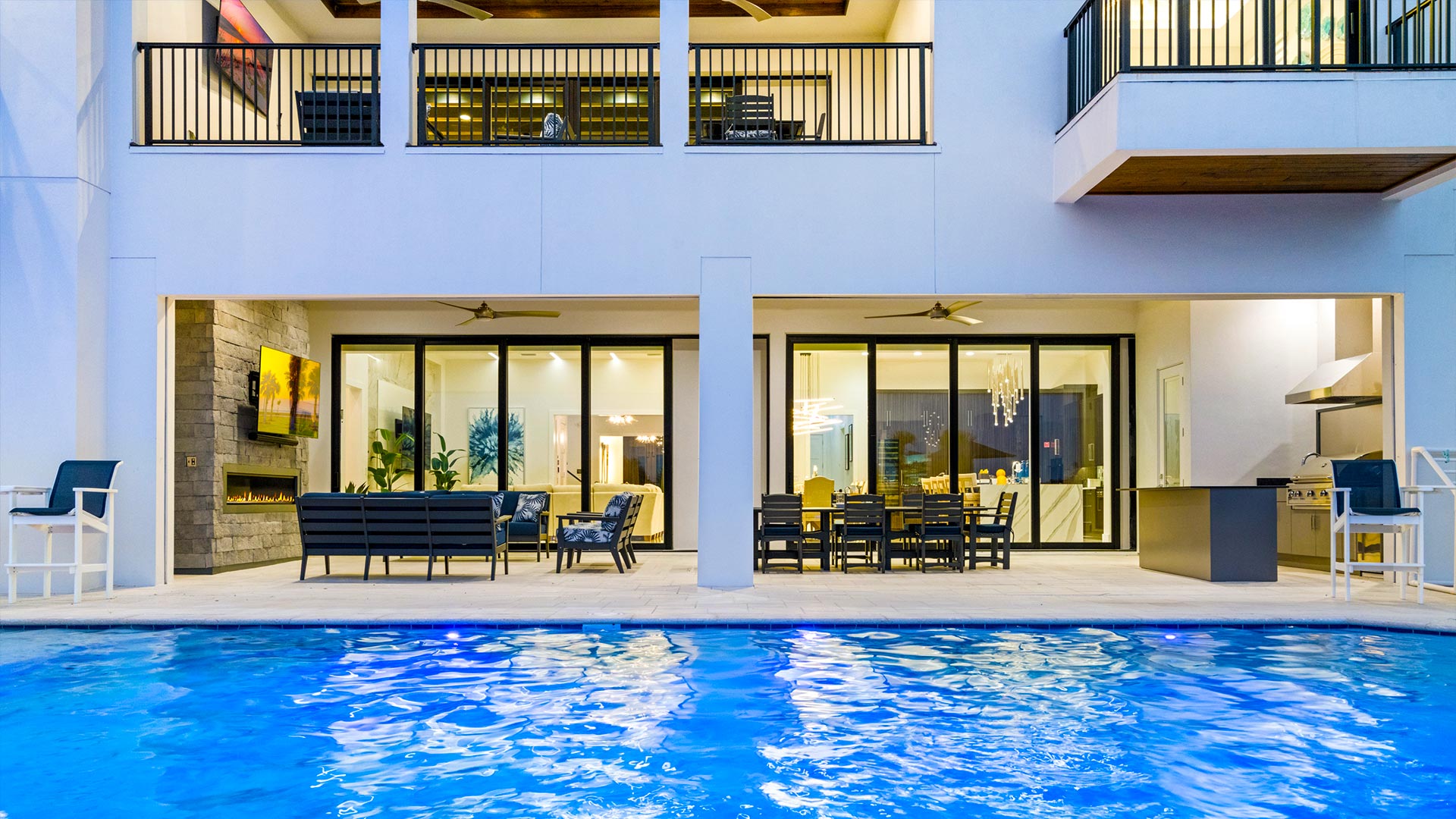 Back Door Of The House Next To The Backyard Pool With Balconies Above